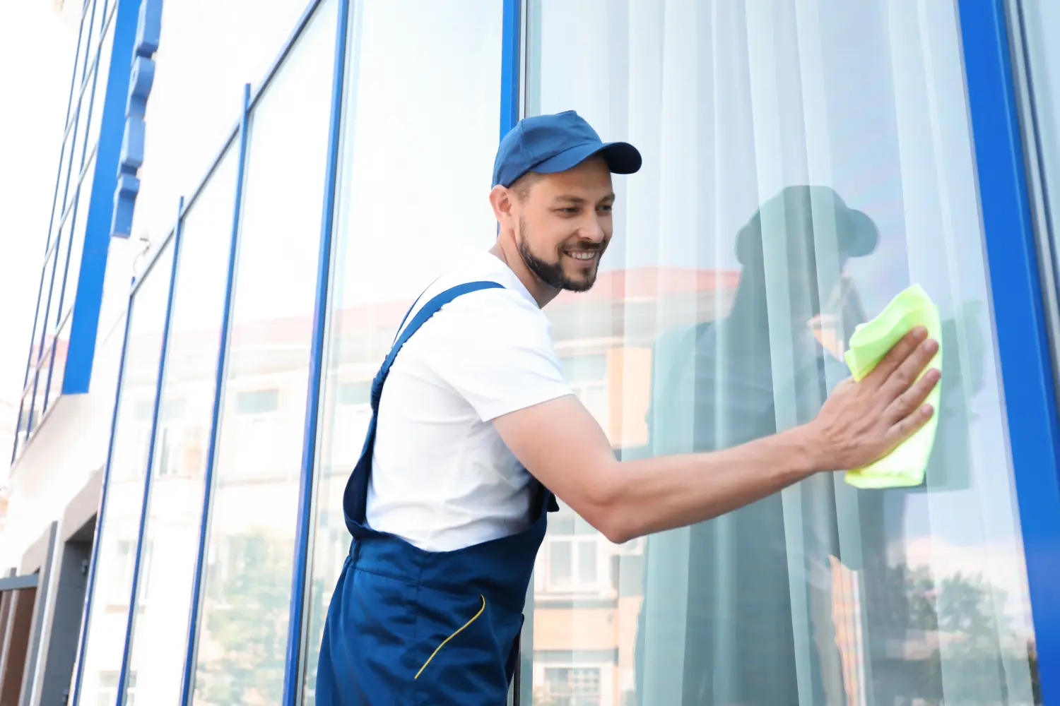 Mannlicher Arbeiter wäscht Fensterglas von außen